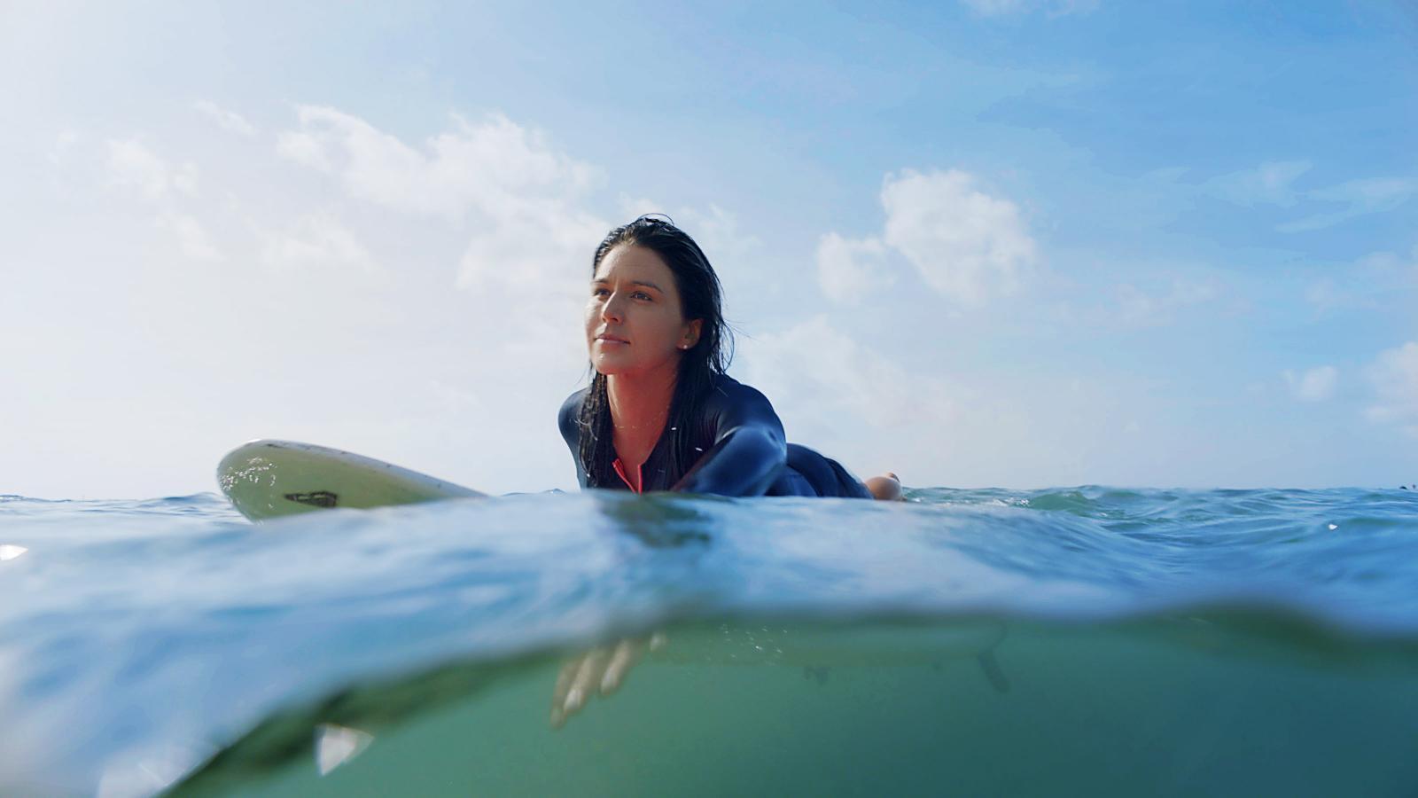 Tulsi Gabbard paddling on a surfboard